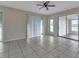 Spacious living room featuring neutral walls, tile flooring, ceiling fan, and sliding glass doors at 211 Dalton Blvd, Port Charlotte, FL 33952