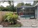 Relaxing screened-in pool area with lounge chairs, surrounded by lush landscaping, creating a private oasis at 2428 Whippoorwill Cir, Sarasota, FL 34231