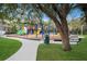 Community playground with swings, slides and benches surrounded by a walking path and mature trees at 352 Chantilly Trl, Bradenton, FL 34212