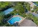 Aerial view showcasing the community pool, tennis courts, lush landscaping, and convenient parking at 3810 75Th W St # 123, Bradenton, FL 34209