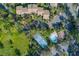 Aerial view of tennis court and pool with community homes and mature trees at 3810 75Th W St # 123, Bradenton, FL 34209