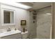 Bright bathroom featuring a framed mirror, white marbled tile shower, and modern fixtures at 3810 75Th W St # 123, Bradenton, FL 34209