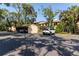 View of the parking area showing carports and guest parking in a lush, treed setting at 3810 75Th W St # 123, Bradenton, FL 34209