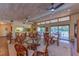 Bright dining area with wood ceiling, glass tables, seating and sliding door to the pool area at 3810 75Th W St # 123, Bradenton, FL 34209