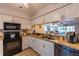 Well-lit kitchen featuring white cabinets, neutral countertops and backsplash, and stainless steel appliances at 3810 75Th W St # 123, Bradenton, FL 34209