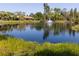 Scenic view of a tranquil pond with a fountain, surrounded by lush greenery and condominium buildings at 3810 75Th W St # 123, Bradenton, FL 34209