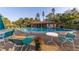 Community outdoor pool with lounge chairs, tables, and adjacent covered area for relaxation at 3810 75Th W St # 123, Bradenton, FL 34209