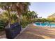 Community pool area featuring a grill and lush landscaping creating a private retreat at 3810 75Th W St # 123, Bradenton, FL 34209