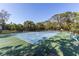 Outdoor tennis court with mature landscaping and seating, perfect for sports and recreation at 3810 75Th W St # 123, Bradenton, FL 34209
