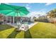 Spacious backyard with lush green lawn, pool, patio area, and mature landscaping at 432 W Gate Dr, Venice, FL 34285