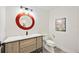 Stylish half bath with unique round mirror, modern vanity, and a comfortable toilet at 432 W Gate Dr, Venice, FL 34285