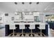 Modern kitchen island with quartz countertop, seating for four, pendant lights and stainless steel appliances at 432 W Gate Dr, Venice, FL 34285
