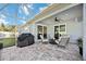 Covered outdoor patio features comfortable seating, a ceiling fan, and sliding door access to the home at 432 W Gate Dr, Venice, FL 34285