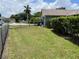 Fenced backyard features green grass, tropical foliage, and well water access at 4509 30Th Street E Cir, Bradenton, FL 34203