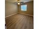 A cozy bedroom featuring laminate flooring, a ceiling fan, and a window offering natural light at 4509 30Th Street E Cir, Bradenton, FL 34203