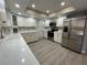 Well-lit kitchen featuring white cabinets, stainless steel appliances, and wood-look floors, with lots of natural lighting at 4509 30Th Street E Cir, Bradenton, FL 34203