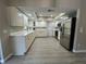 Bright kitchen featuring white cabinets, stainless steel appliances, wood-look floors, and a skylight for natural lighting at 4509 30Th Street E Cir, Bradenton, FL 34203