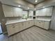 Charming kitchen featuring white cabinets, wood-look floors, stainless steel appliances, and a bright window over the sink at 4509 30Th Street E Cir, Bradenton, FL 34203