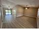 Open concept living room with ceiling fan, wood-look floors, and sliding doors to the pool area and kitchen at 4509 30Th Street E Cir, Bradenton, FL 34203