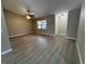 Spacious living room featuring wood-look flooring, a ceiling fan, a large window, and a view of the front door at 4509 30Th Street E Cir, Bradenton, FL 34203