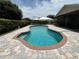 A stunning freeform pool is surrounded by a brick-paved deck and a meticulously landscaped backyard at 4509 30Th Street E Cir, Bradenton, FL 34203