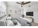 Comfortable bedroom with a ceiling fan, television, and two bright windows at 4608 Park Acres Dr, Bradenton, FL 34207