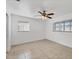 This bedroom features tile floors, two windows, and a ceiling fan with overhead lighting at 4608 Park Acres Dr, Bradenton, FL 34207