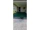 View of covered front porch with green flooring and black front door at 4608 Park Acres Dr, Bradenton, FL 34207