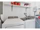 Functional laundry room with modern washer, dryer, storage shelves, and water heater at 4608 Park Acres Dr, Bradenton, FL 34207