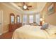 Well-lit bedroom showcases stylish tray ceiling, a ceiling fan, three sunny windows, and wood-look floors at 5020 Savona Run, Bradenton, FL 34211