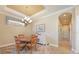Cozy dining room featuring a tray ceiling, elegant chandelier, and a decorative area rug at 5020 Savona Run, Bradenton, FL 34211