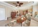 View of the cozy living room, with a ceiling fan and furniture, as well as the kitchen and dining area at 5020 Savona Run, Bradenton, FL 34211