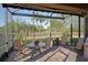 Enclosed back patio with seating area and views of the tropical landscaping at 5020 Savona Run, Bradenton, FL 34211