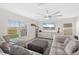 Bright living room featuring a large window, gray sectional sofa, and modern ceiling fan at 5132 Rocky Coast Pl, Palmetto, FL 34221