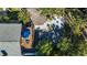 Aerial view of backyard showcasing a firepit area with Adirondack chairs and a covered patio with a blue umbrella at 5250 Calle De Rio, Sarasota, FL 34242