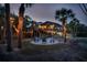 Charming backyard with a firepit surrounded by palm trees and string lights, creating an inviting outdoor space at 5250 Calle De Rio, Sarasota, FL 34242