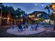 Backyard with outdoor seating surrounding a fire pit, enhanced by string lights and lush greenery at 5250 Calle De Rio, Sarasota, FL 34242