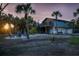 Inviting backyard with seating area, string lights, lush palm trees, and exterior stairs to deck at 5250 Calle De Rio, Sarasota, FL 34242