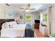 Inviting bedroom features terracotta flooring, a ceiling fan, and large window views to the yard at 5250 Calle De Rio, Sarasota, FL 34242