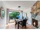 Dining room with fireplace and sliding glass doors out to a tropical-landscaped deck at 5250 Calle De Rio, Sarasota, FL 34242