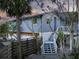 Charming exterior showcasing a staircase leading to a deck, complemented by lush landscaping at 5250 Calle De Rio, Sarasota, FL 34242