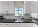 Stylish kitchen with gray countertops, white cabinets, and subway tile backsplash at 5250 Calle De Rio, Sarasota, FL 34242