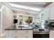 Open concept kitchen with a large island, modern appliances, and seamless flow to the living area with a stone fireplace at 5250 Calle De Rio, Sarasota, FL 34242