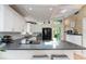 Well-lit kitchen with an island, white cabinets, and modern appliances at 5250 Calle De Rio, Sarasota, FL 34242