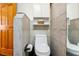 Cozy water closet includes modern toilet, tiled walls, and built in storage at 5250 Calle De Rio, Sarasota, FL 34242