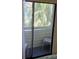 Balcony with sliding glass door, view of trees and outdoor seating at 625 Duchess Blvd, Dunedin, FL 34698