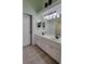 Bright bathroom featuring double sinks, dual mirrors, and white cabinetry at 625 Duchess Blvd, Dunedin, FL 34698