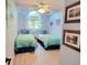 Comfortable bedroom with twin beds, ceiling fan, and serene, light-filled ambiance at 625 Duchess Blvd, Dunedin, FL 34698