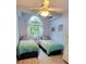 Charming bedroom with twin beds, ceiling fan, and arched window providing natural light at 625 Duchess Blvd, Dunedin, FL 34698