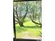 A serene outdoor view from this home's screened lanai, showcasing mature trees at 625 Duchess Blvd, Dunedin, FL 34698